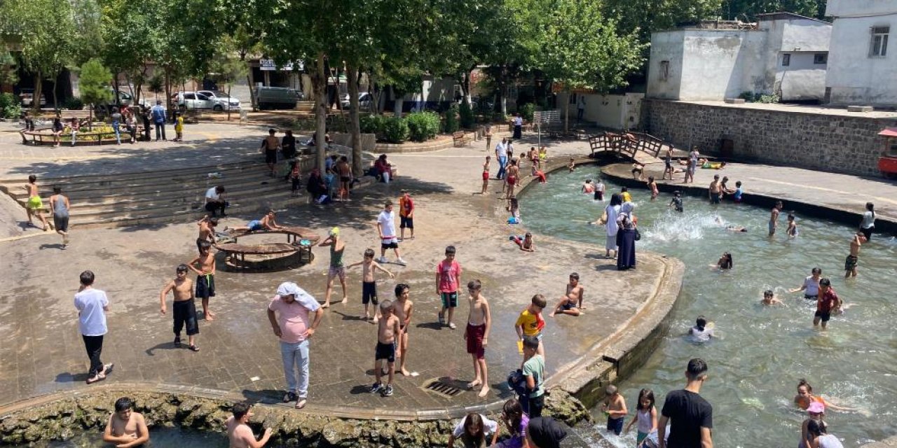 Diyarbakır'da çocuklar ailelerinin nezaretinde süs havuzunda serinliyor